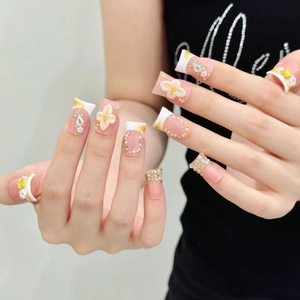 Nude French press-on nails with 3D resin flowers, pearls, and rhinestones