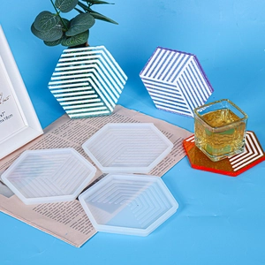Hexagonal striped silicone molds with colorful resin coasters on a blue background