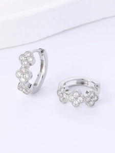 Detail of silver floral hoop earrings featuring three small zircon clusters in 45-degree view