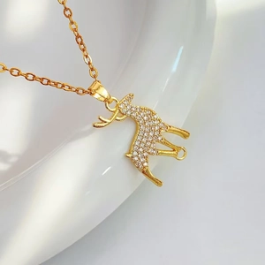 Macro detail of a golden elk pendant necklace with micro-paved sparkling cubic zirconia