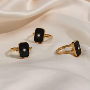 Trois bagues dorées 18K avec émail noir carré et petit cristal de zircone rond