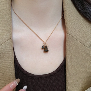 Close-up of elegant tiger eye stone double gourd pendant necklace with gold chain