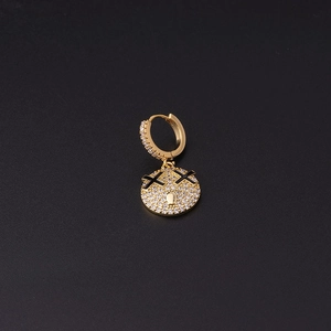 Detail of gold-plated earring featuring a micro-pave zircon smiling face with X eyes