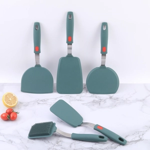 Dark green silicone turner set with stainless steel handles on marble background