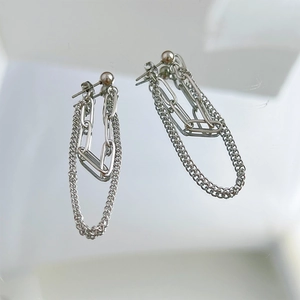 Detail of silver double-layered tassel chain earrings with hip-hop style metallic finish