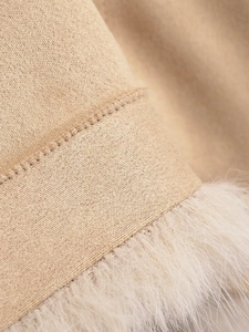 Detailed macro view of beige knit texture and soft faux fur trim on the winter jacket sleeve