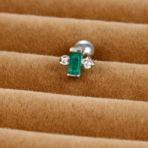 Macro detail of emerald green zircon earring with silver screw back and cubic zirconia