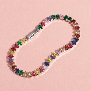 Macro detail of rainbow tennis bracelet featuring pear-cut stones and fold-over clasp