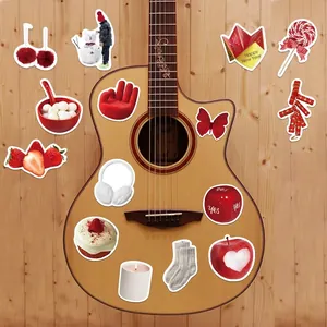 Flat lay of red Lunar New Year stickers on a guitar and wooden floor backdrop