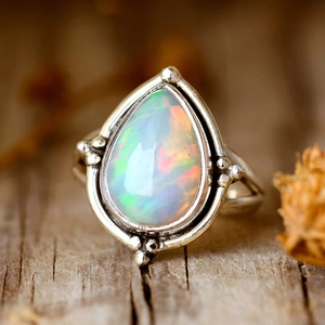Détail macro d'une bague opale en goutte avec monture argentée de style vintage