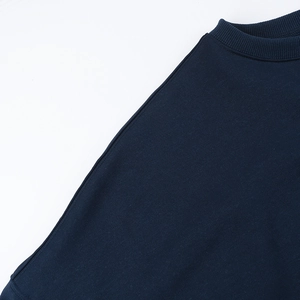 Detailed close-up of crew neckline and reinforced shoulder stitching on navy sweatshirt