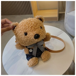 Detail of cute brown plush bear crossbody bag with denim overalls and checkered bow decoration