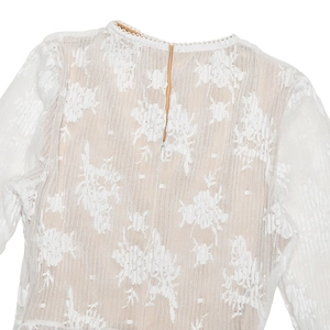 Détail du dos en dentelle florale d'une robe blanche avec fermeture éclair invisible