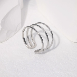 Detailed close-up of a silver triple-layered open ring with a hammered texture finish