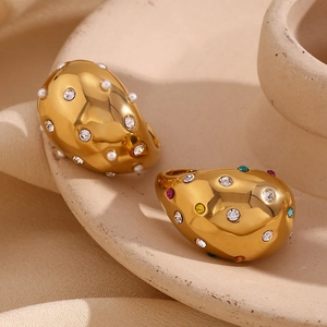Detail view of 18K gold plated teardrop rings with hammered texture on ceramic tray