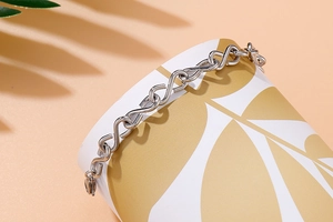 Detailed close-up of a silver stainless steel infinity S-link bracelet on a display stand