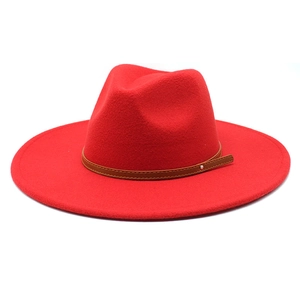 Detail of red wool felt fedora featuring a brown leather band and metal buckle accent