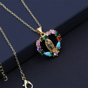 Detail of gold Virgin Mary pendant featuring colorful micro-pave crystals on black leather