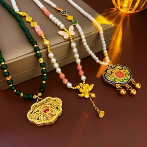 Vintage Chinese gold necklaces with lotus and enamel lock pendants on brown leather case