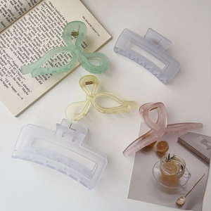 Five assorted colorful acrylic shark hair claws set displayed on a minimalist white desk
