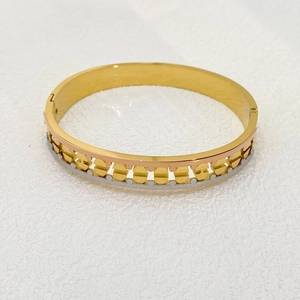 Detail of tricolor stainless steel bangle showing hollow geometric patterns and side clasp
