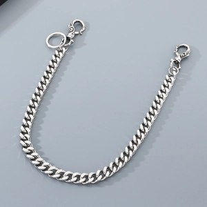Silver Cuban link trouser chain with skull lobster clasps on a clean grey background