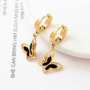 Macro shot of 18K gold butterfly hoop earrings with black enamel and hollow wings