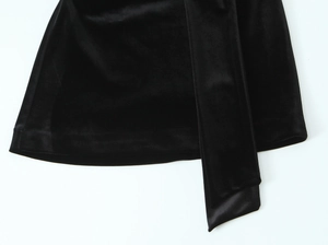Détail du tissu en velours noir et de l'ourlet en satin de cette robe de soirée