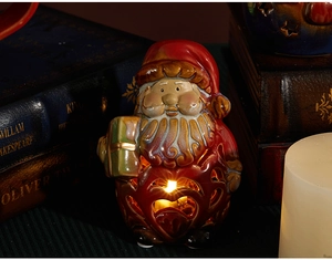 Close-up of a ceramic Santa Claus ornament with heart hollow design and warm LED light