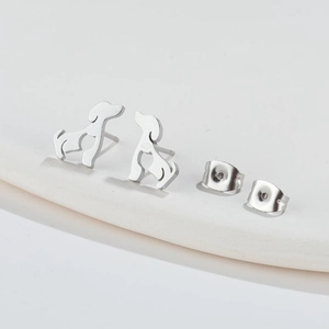 Macro detail of dog-shaped stainless steel earrings with butterfly backings