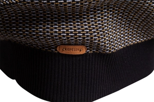 Vue macro de la maille du pull avec écusson logo en cuir marron et ourlet côtelé