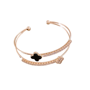 Rose gold double-layer open bangle with black and zircon clover charms on white background