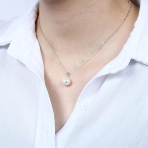 Close-up of elegant S925 silver necklace with a lustrous white pearl pendant on a model
