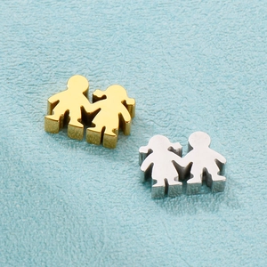 Detail of stainless steel boy and girl shaped pendants in gold and silver finish
