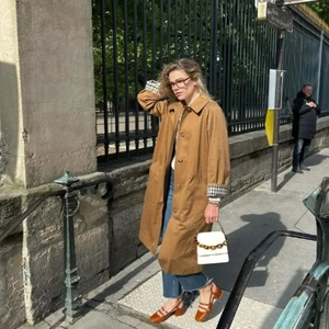 Caramel Einreihiger Trenchcoat mit Karofutter in einer urbanen Straßenszene gezeigt