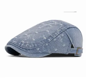 Detail view of light blue denim newsboy hat with white diamond stitching and metal buckle