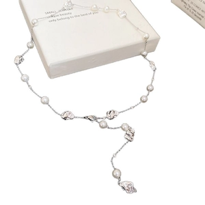 Collana con perle sintetiche irregolari e metallo liquido su una confezione regalo