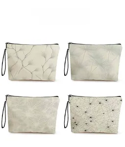 Quattro trousse in tela beige con motivi floreali a dente di leone e cerniere nere