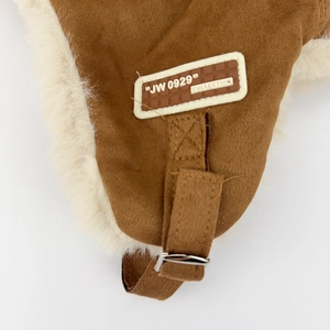 Detail of winter trapper hat showing brown suede fabric and adjustable metal buckle strap