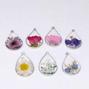 Teardrop resin pendants with colorful dried flowers and gold leaf in silver frames