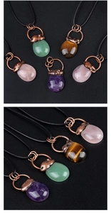 Macro shot of assorted natural stone pendants in amethyst and tiger eye with copper detail