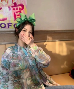 Close-up of green seersucker oversized bow headband styled with a tropical print shirt