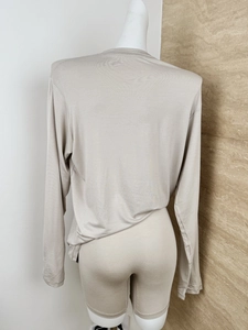 Rear view of beige long-sleeve knit T-shirt and slim shorts set for loungewear