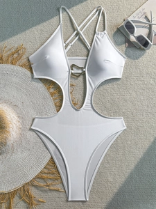Detail of white cutout one-piece swimsuit with golden heart ring and cross straps