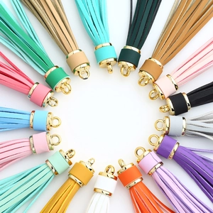 Colorful PU leather tassel keychains with gold metal caps arranged in a circular layout