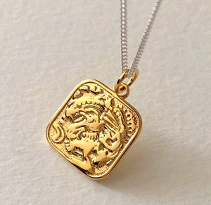 Detailed macro view of the vintage square gold pendant with lion relief carving