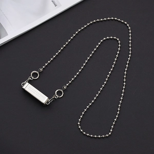 Detail of silver metal ball chain with engraved Good Luck rectangular pendant charm