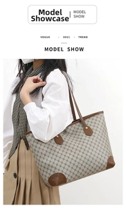 Detailed view of beige canvas tote bag with brown monogram pattern and leather strap