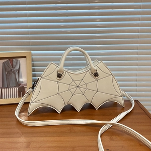 Detail view of white bat-wing PU leather handbag with spider web stitching and cross buckle