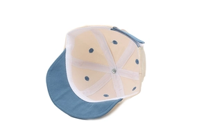 Detail view of cotton baby baseball cap interior showing blue brim and metal top button
